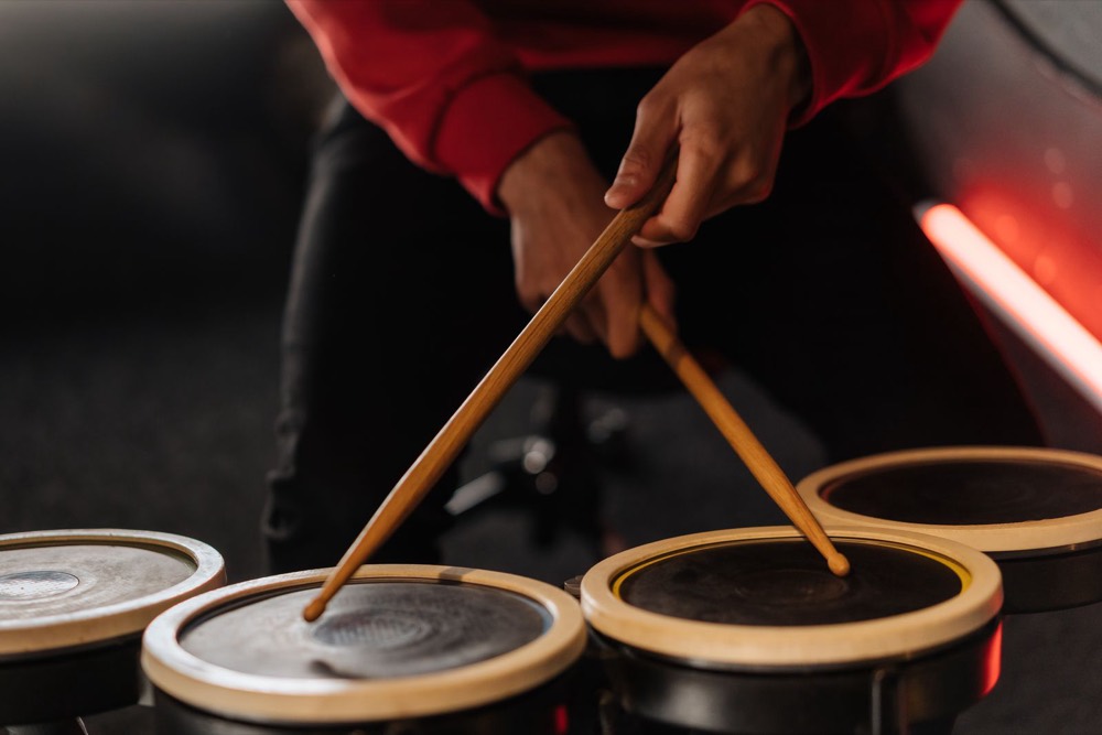 Hände mit Drumsticks in Bewegung über Drum-Pads